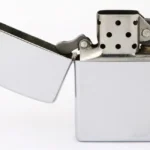 a silver lighter with a white background